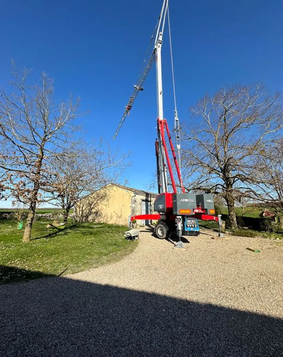 Grue mobile en action | Patrimoine Restauration Grue mobile sur remorque dans un jardin ensoleillé