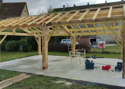 Construction d'une charpente en bois sur dalle de béton.